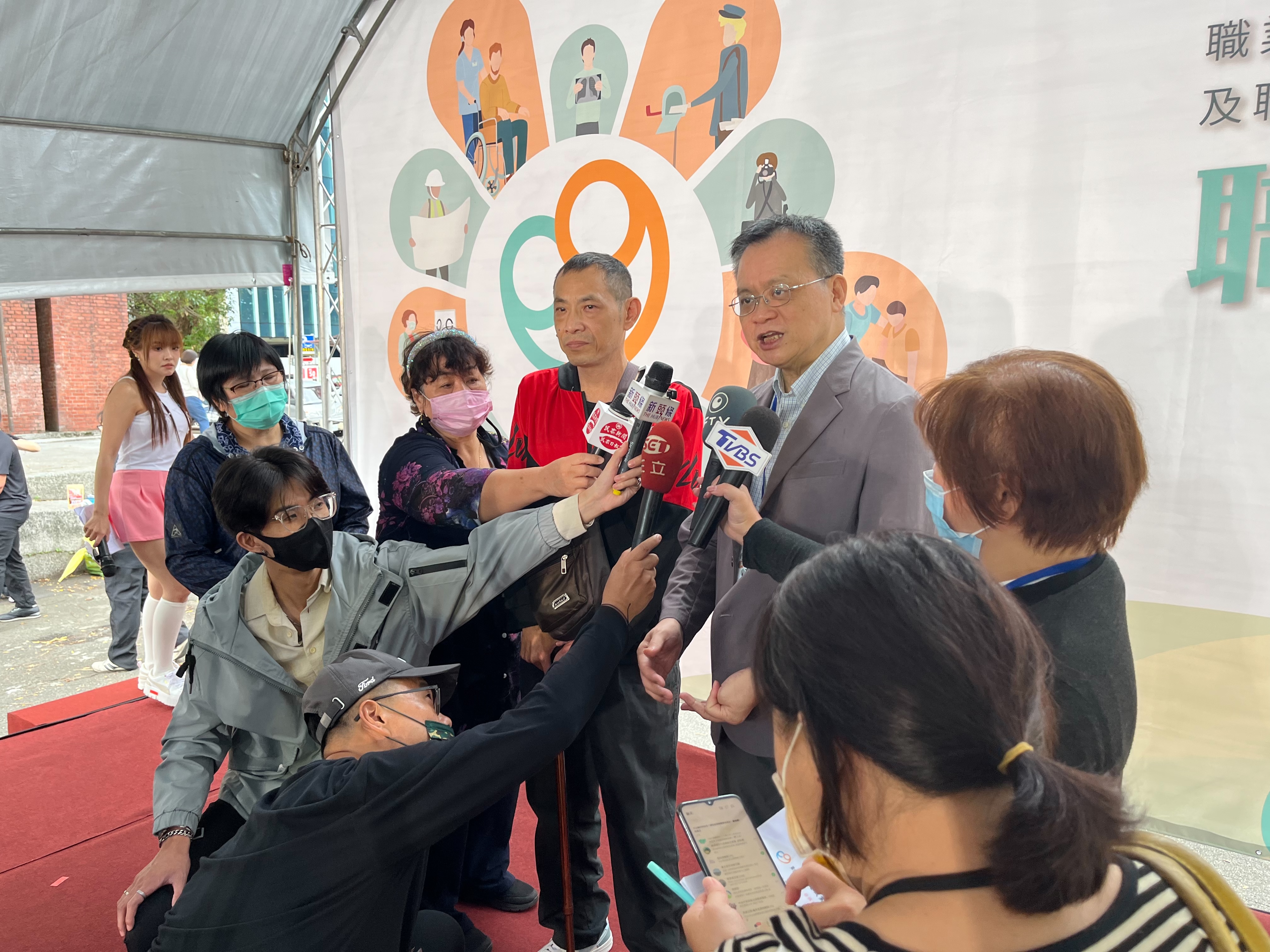 労働安全衛生署の鄒子廉署長が被災労働者とともにイベント終了後にマスコミの合同インタビューに対応